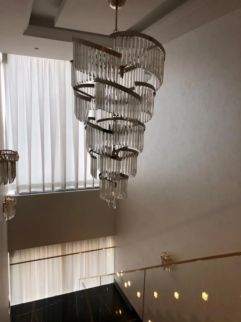scară interioară într-un duplex premium cu marmură neagră, sticlă și candelabru